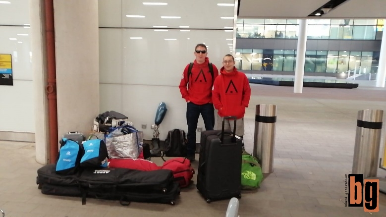 Two men standing next to a lot of luggage